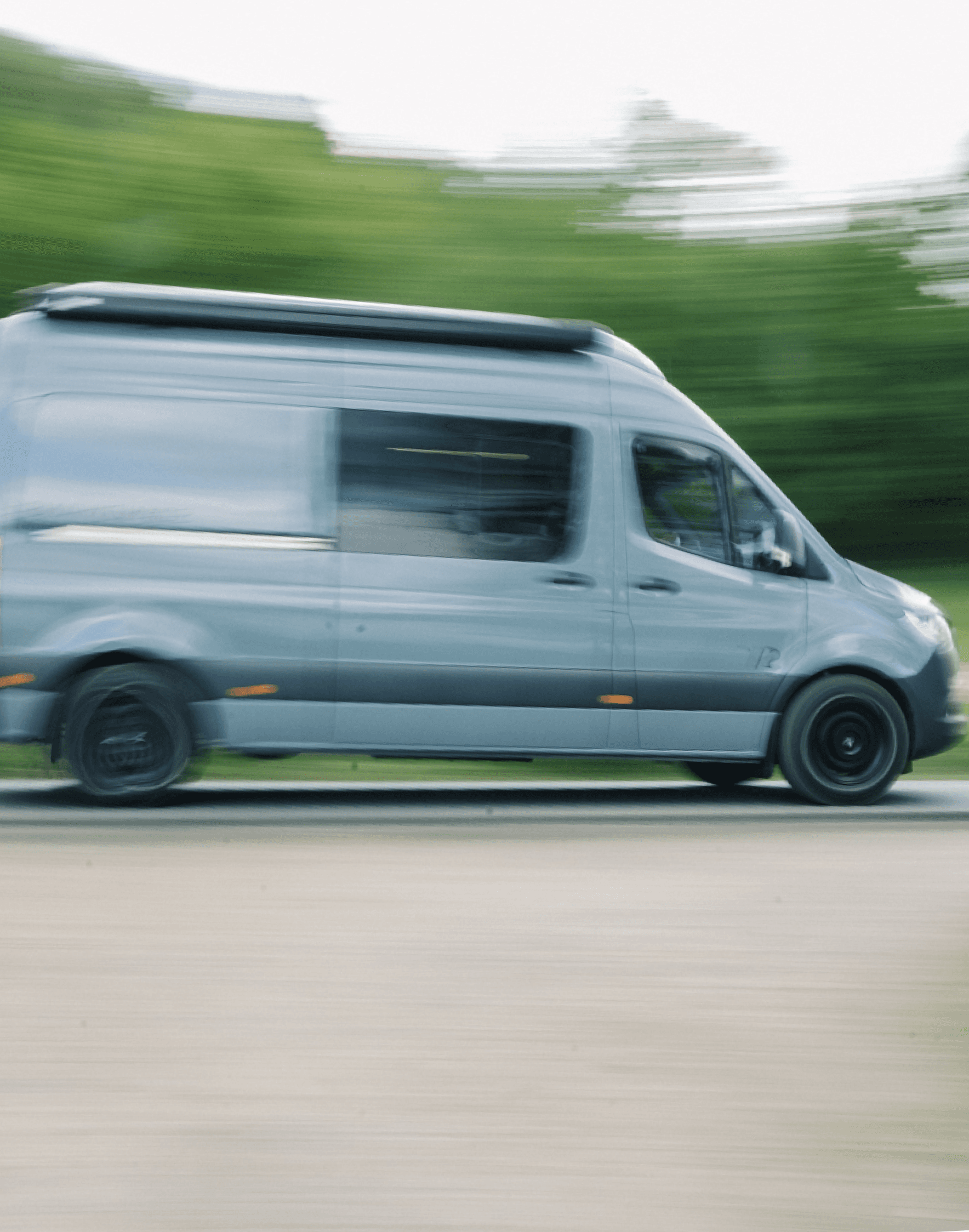 Campervan driving past greenery